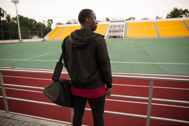 Back view of a young african sportsman standing at the stadium - Foto, Bild