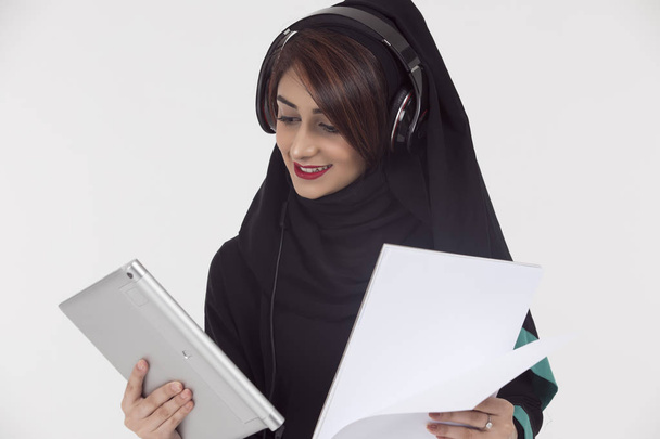Arapça öğrenci abaya, holding beyaz kağıt ve tablet - Fotoğraf, Görsel