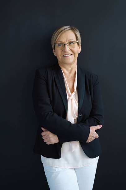 Friendly senior businesswoman with folded arms - Photo, image