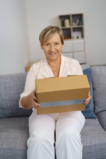 Senior woman holding cardboard box - Fotó, kép