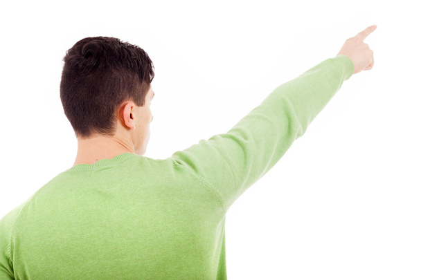 Young casual man pointing over white background - Foto, Bild