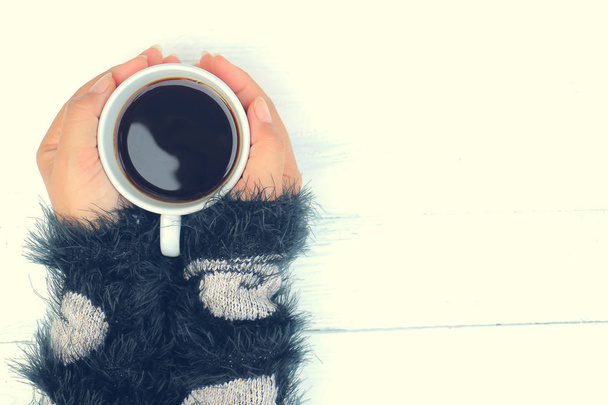 Menschliche Hand im Frühlingshemd mit Tasse Kaffee  - Foto, Bild