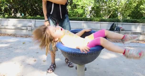 Szczęśliwa dziewczynka przędzenia na krzesło plac zabaw - Materiał filmowy, wideo