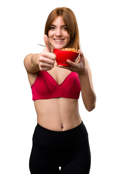 Mladý sportovní žena jíst obiloviny z mísy - Fotografie, Obrázek