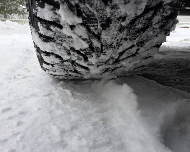 Primer plano del neumático del coche cubierto de nieve
 - Foto, imagen