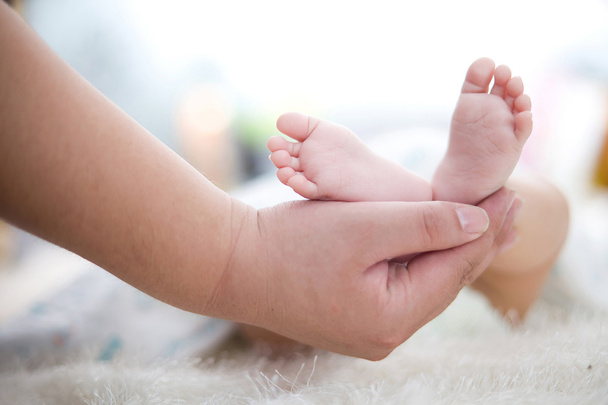 Mother's hand hold baby's foot - Φωτογραφία, εικόνα