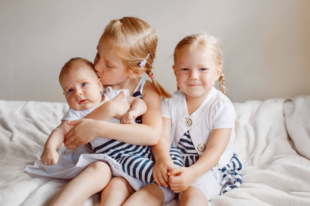  hermanas sosteniendo pequeño bebé
 - Foto, imagen