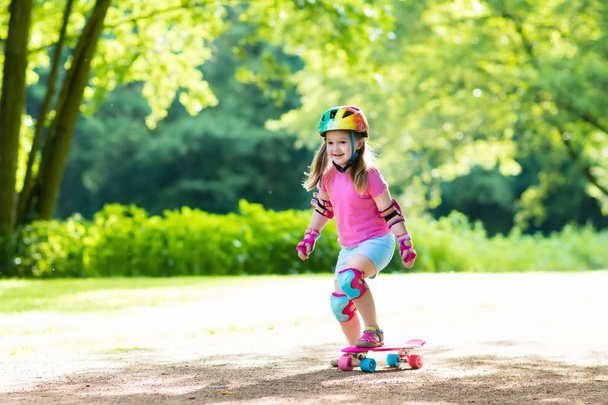 Kind paardrijden skateboard in zomer park - Foto, afbeelding