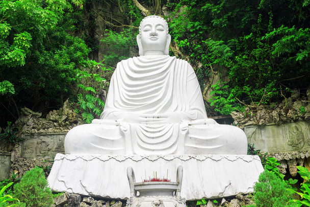 Величественный вид на статую белого Будды среди листвы деревьев
 - Фото, изображение