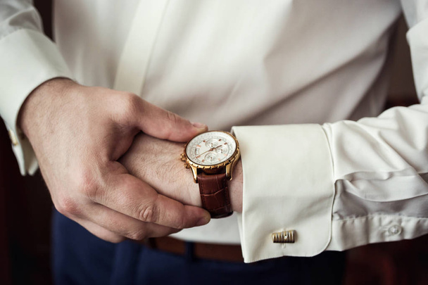 businessman clock clothes, businessman checking time on his wristwatch. men's hand with a watch, watch on a man's hand, the fees of the groom, preparation for work, putting the clock on the hand, fasten clock watch time, man's style - Фото, зображення