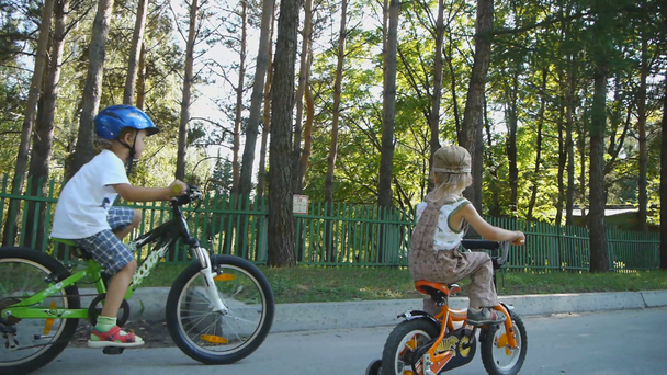 iki küçük çocuk bir güneşli yaz günde bir bisiklet sürme. - Video, Çekim