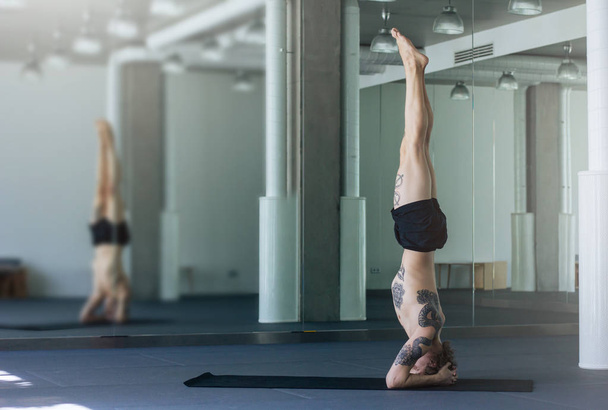  Handsome tattooed man practicing yoga. Young male teacher takin - Photo, image