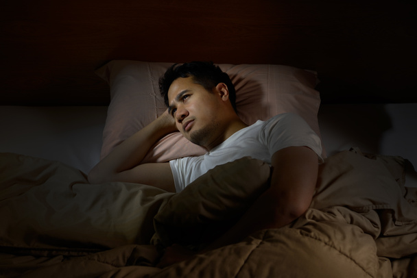 Depressed man suffering from insomnia lying in bed - Foto, Imagem