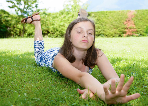 ładny pre teen dziewczyna leżące w trawie - Zdjęcie, obraz
