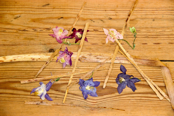 Gedroogde verwelkte bloemen op een donkere houten ondergrond - Foto, afbeelding