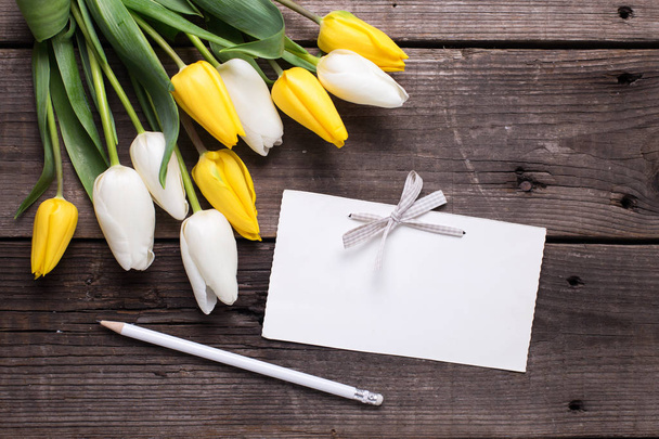 Lege tag, potlood en heldere tulpen - Foto, afbeelding