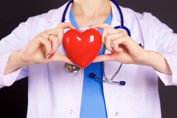 Female doctor with the stethoscope holding heart - Foto, Bild