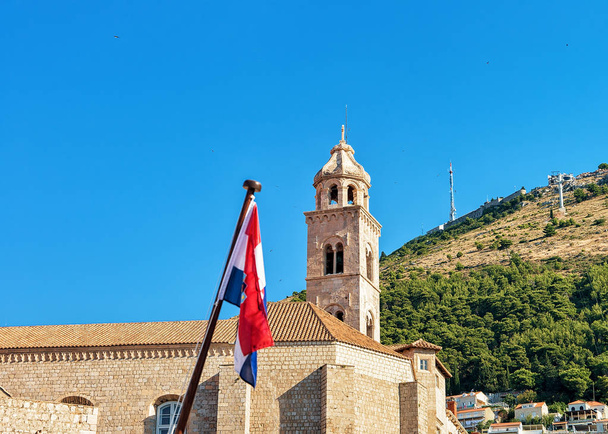 Torre de la Iglesia Dominicana y bandera en el casco antiguo de Dubrovnik
 - Foto, Imagen