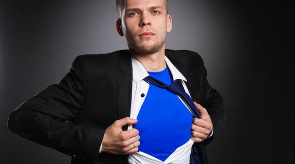 青年実業家演技スーパー ヒーローのような灰色の背景に分離された彼のシャツを引き裂く - 写真・画像