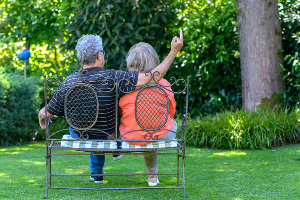Seniorenpaar sitzt auf einer Gartenbank - Foto, Bild