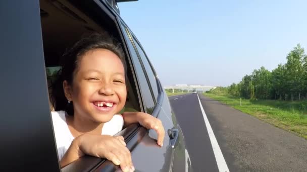 Vrolijke tandeloze meisje uit te kijken van autoruiten - Video