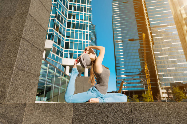 Young girl doing yoga outdoors in city - Foto, Imagem
