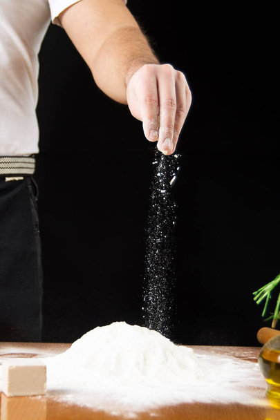 Człowiek, dodając mąkę na stos ręcznie - Zdjęcie, obraz