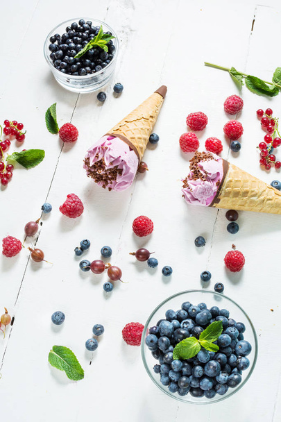 ice cream scoops with fresh berries on white wood background. - Fotoğraf, Görsel