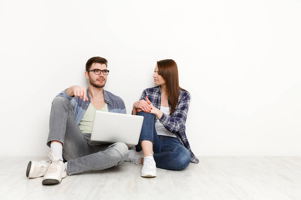 Couple avec ordinateur portable penser à un nouveau projet de travail à l'intérieur de la maison
 - Photo, image