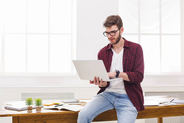 Молодий концентрований бізнесмен використовує ноутбук в офісі
 - Фото, зображення