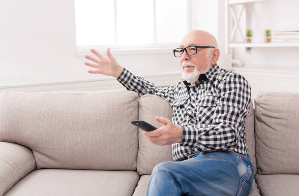 Emotional senior man watching tv copy space - Foto, imagen