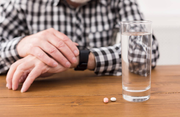 Senior man hands with glass of water and pills - Foto, Imagem