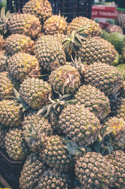 Куча ананасов на азиатском органическом рынке, крупный план. Тропический остров Бали, Индонезия
. - Фото, изображение