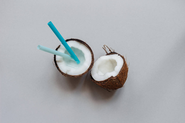 Ripe coconut with straw on the gray background, top view, with copy space - Fotoğraf, Görsel