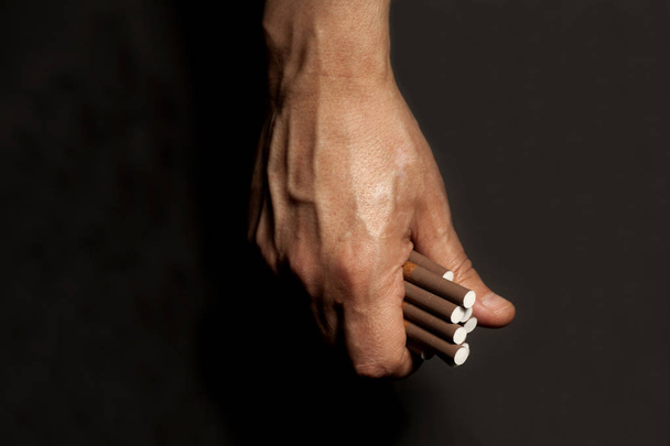 Tobacco addiction. Cigarettes on man hand.  - Foto, Bild