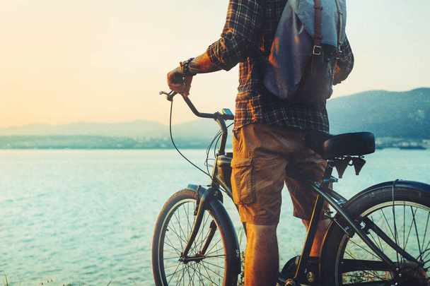 Unrecognizable Traveler Man Standing With Bike On Coast And Enjoying View of Nature Sunset Vacation Traveling Relaxation Resting Concept - Foto, immagini