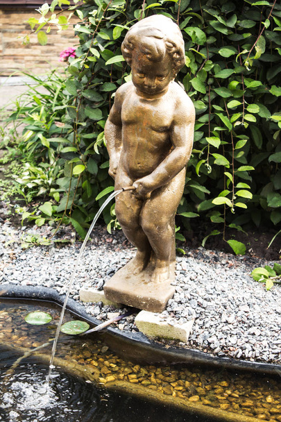 Una estatua de un niño en el jardín
 - Foto, Imagen
