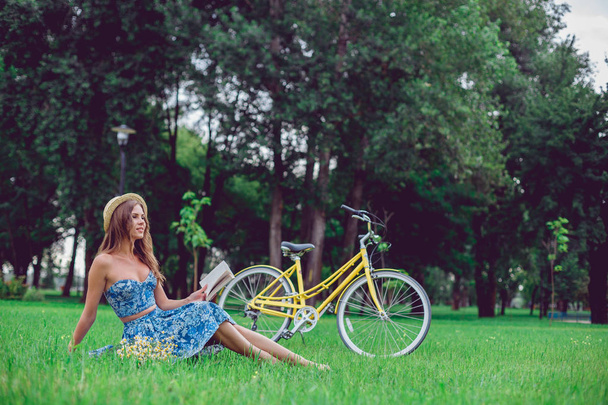 Krásná mladá žena portrét čtení knihy s kolo v parku. - Fotografie, Obrázek