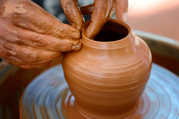 Potter making ceramic pot on the pottery wheel - Fotó, kép