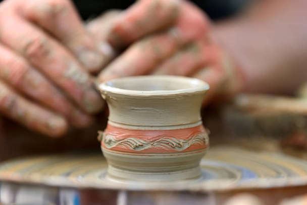 Potter making ceramic pot on the pottery wheel - Фото, зображення