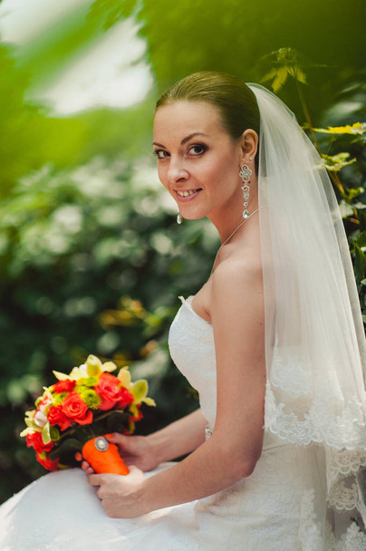 Mooie elegante bruid met gebundelde haren voor een wandeling in de open - Foto, afbeelding