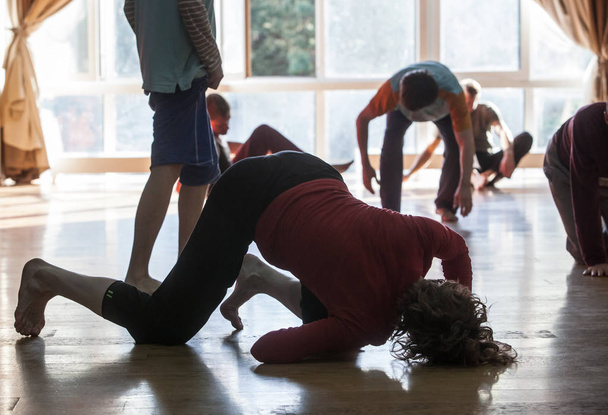 dansers beweging, abstract. Dansers leunen op elkaar, silhouet op blured achtergrond, op verdieping, prestaties dansimprovisatie - Foto, afbeelding