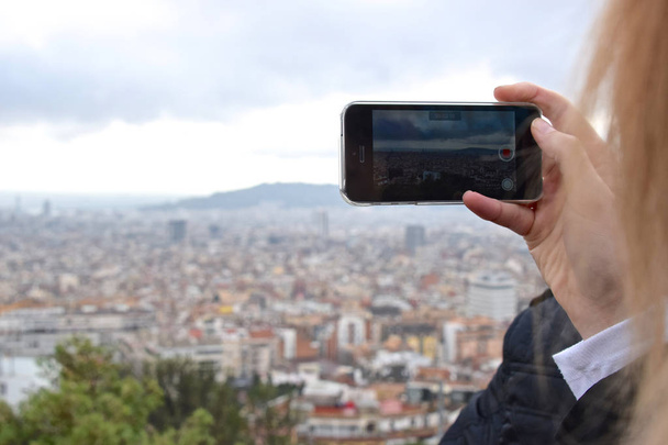 Woman records a video overlooking a large city - Foto, Bild