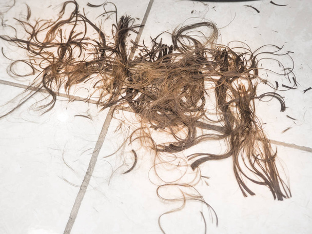 Κομμένα μαλλιά μετά από ένα κούρεμα στο κομμωτήριο. Γκρο πλαν. - Φωτογραφία, εικόνα