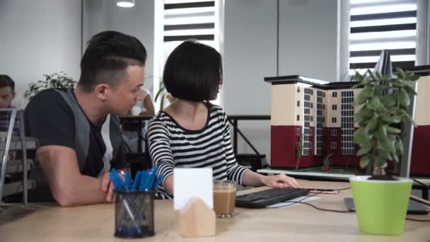 Man and woman discussing in front of computer - Materiaali, video