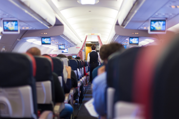 Intérieur de l'avion commercial avec passagers sur les sièges pendant le vol
. - Photo, image