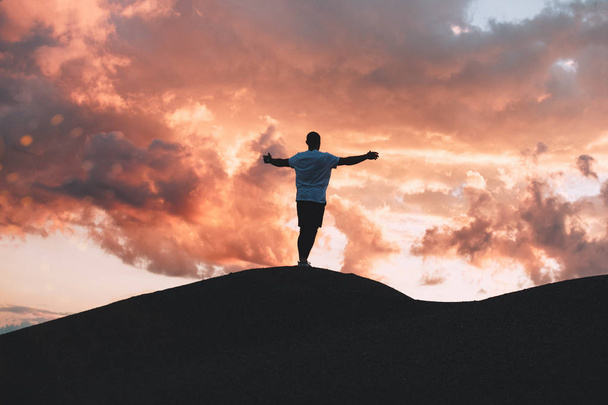 Щасливий чоловік спортсмен з руками вгору, стоячи на пагорбі на заході сонця
 - Фото, зображення
