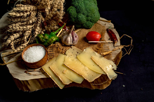 Нарезанный вручную сыр на деревянной доске
 - Фото, изображение