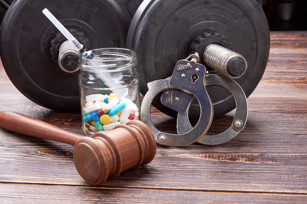 Gavel, jar with pills, handcuffs, dumbbells. - Photo, Image