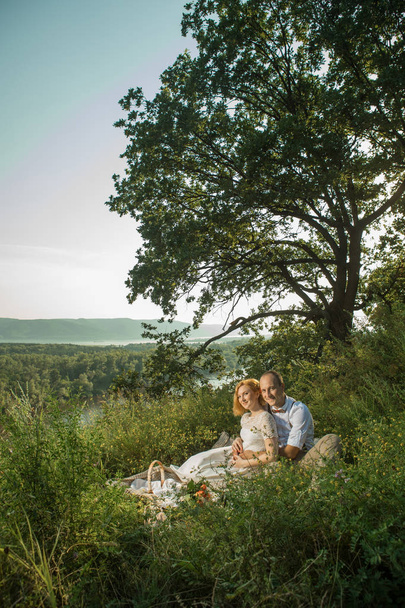 Attractive Couple Enjoying Romantic Sunset Picnic in the Countryside - Φωτογραφία, εικόνα